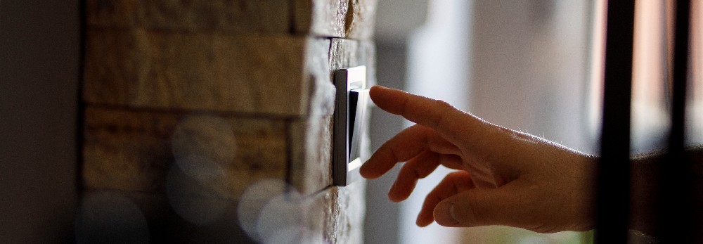 Hand betätigt einen Lichtschalter.